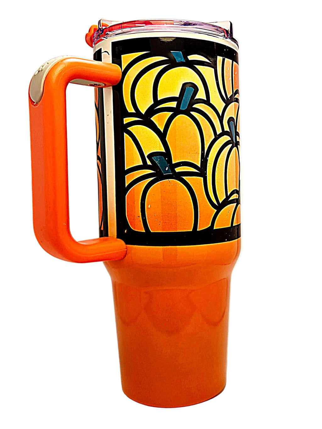 An orange insulated travel tumbler with a large integrated handle and a clear lid, decorated with a black band featuring a repeating pumpkin pattern in orange.